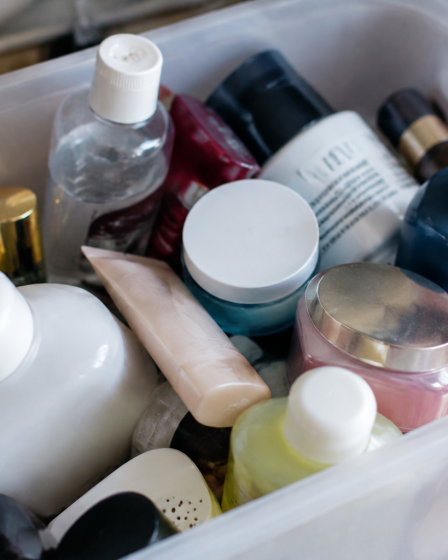 Flacons et pots cosmetiques accumules dans un bac