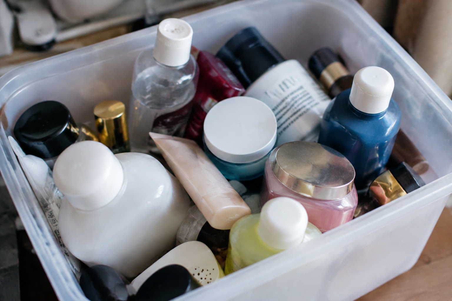 Flacons et pots cosmetiques accumules dans un bac