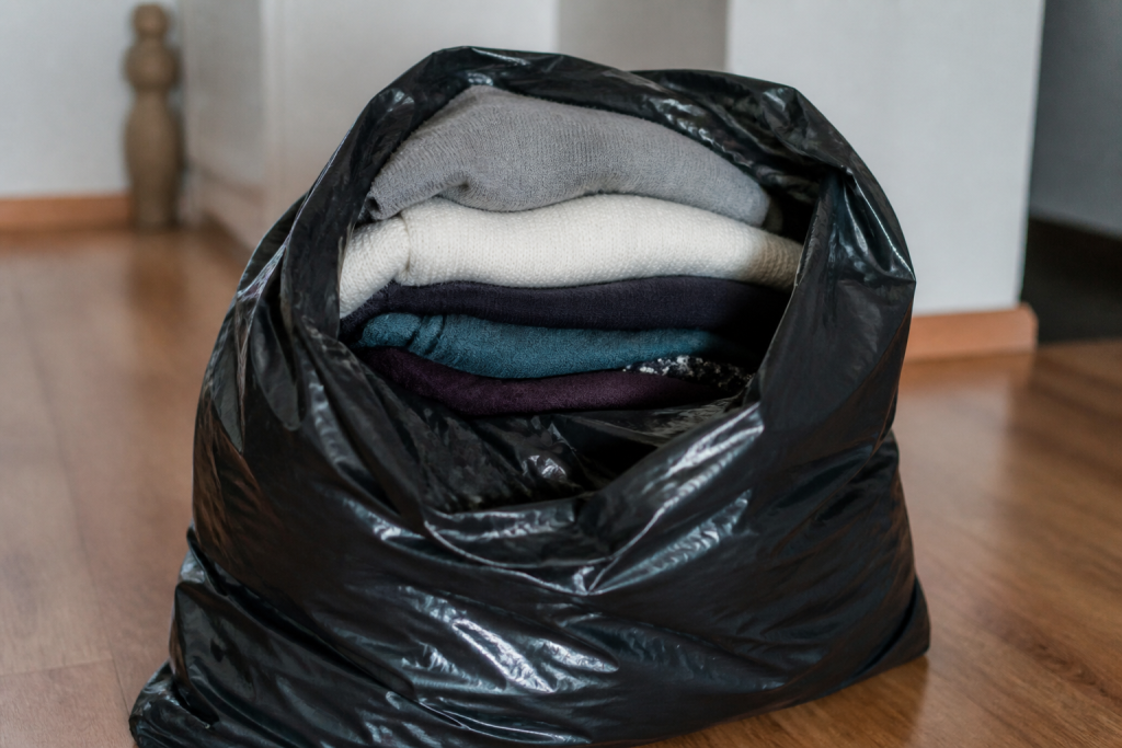 Vetements plies dans sac plastique noir ferme