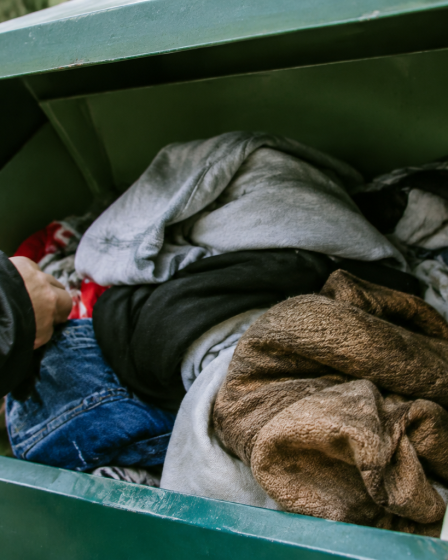 Vetements usages accumules dans un bac de collecte