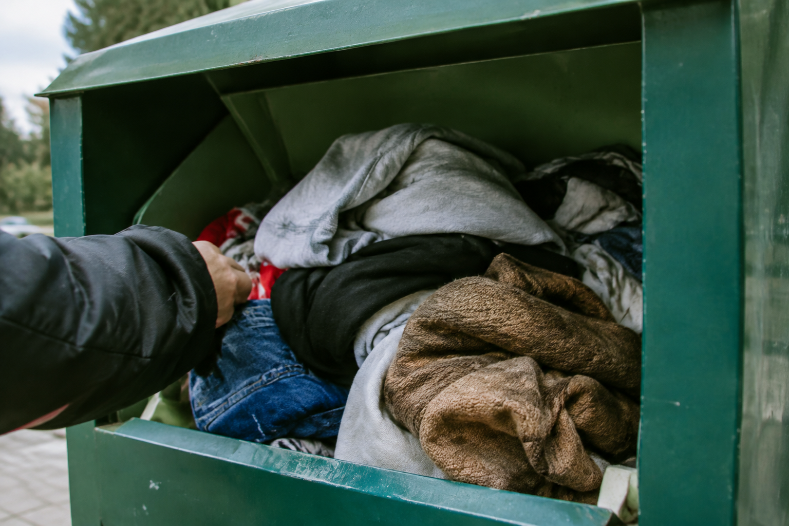 Vetements usages accumules dans un bac de collecte